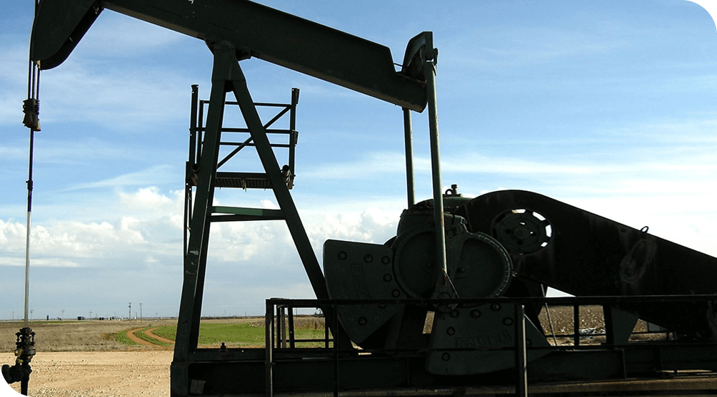 Pump Jack in a Middle of a Field Pumping